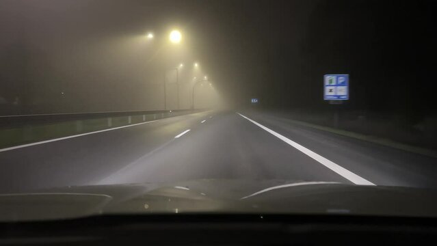 Driving in thick fog at night. View from inside car