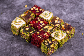 Turkish delight on a dark background. Traditional Turkish delicacies. Varieties of Turkish Delight with Pistachio. close up