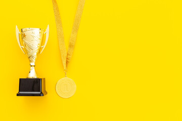 Winner and success background - gold medal and trophy cup, top view