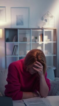 Facepalm gesture. Displeased woman. Clueless task. Embarrassed lady covering face with hand feeling epic fail sitting desk light room interior looped vertical.