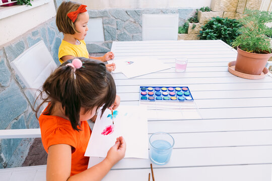 Cute girls painting with watercolor