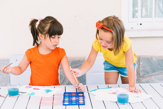 Girls painting together at table