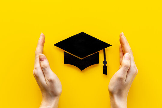 Students hands with graduation hat or academic cap paper cut