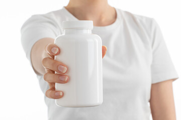 Close up image of woman holding a white bottle
