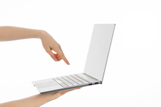 Close up image of woman's hand holding a laptop.