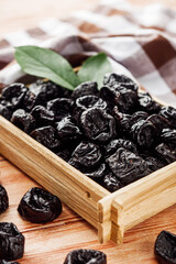 delicious dried prunes on a wooden rustic background