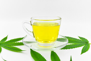 Hemp herbal tea, Hot Hemp in a glass cup with tea leaves on white background.