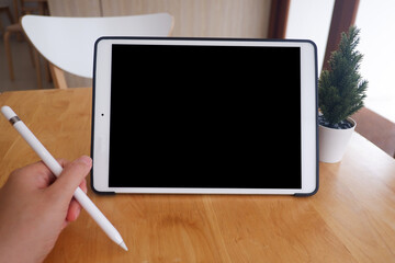 Mockup picture of business woman’s hands using tablet with white blank screen in modern place