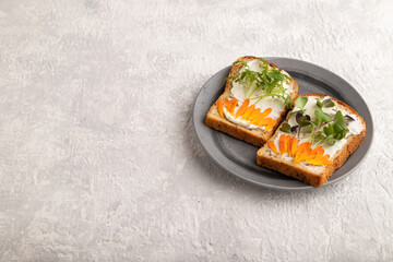 White bread sandwiches with cream cheese, calendula and microgreen on gray. side view, copy space.
