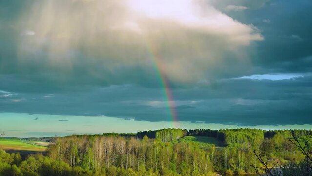 The disappearance of the rainbow over the spring forest. Rainbow time lapse after a spring thunderstorm. High quality FullHD footage. High quality FullHD footage
