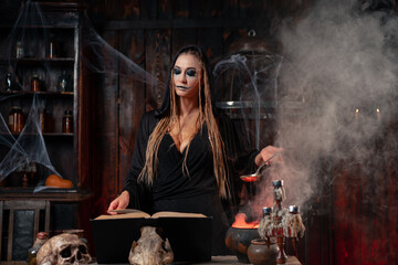 Fototapeta na wymiar Halloween, witch use magic book and cauldron prepare poison or love potion