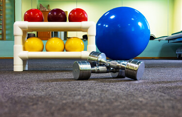 Sports equipment - a balls, big ball, dumbbells  in the room, training hall. Care of health, body care and figure. 