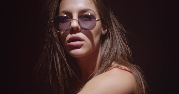 Cool girl with sunglasses smoking and dancing seductively