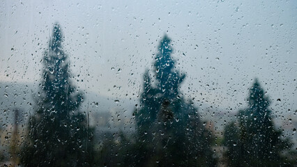 Bluish raindrops on the blurry window  