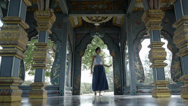 Asian Woman Inside The Ornamented Pavilions Of Ancient City Muang Boran In Bangkok, Thailand. Low Angle Shot