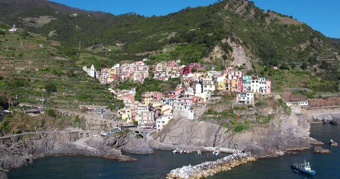 Beautiful small historic town Manarola on rocky cliff, Italian coast. Popular travel destination - drone pull back