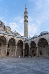 Inner courtyard of the Suleiman Mosque in Istanbul, with the view of a minaret in its corner. With the blue sky, with some cloud at sunset.