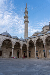 Inner courtyard of the Suleiman Mosque in Istanbul, with the view of a minaret in its corner. With the blue sky, with some cloud at sunset.