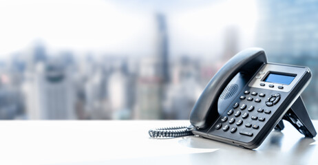 telephone with VOIP on white table on blurred city background. customer service support, call...