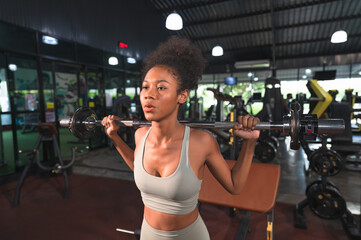 Fototapeta premium African American woman bodybuilder training back doing deadlift with barbel and weights in the fitness gym
