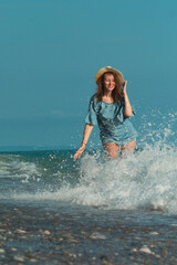 a beautiful girl in summer on the seashore happily having fun on the water with emotions