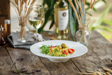 Portion of italian spaghetti pasta with olives and herbs