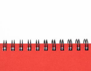 Close up of spirall notebook with red cover on white background