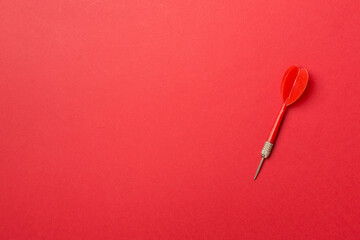 Red dart on color backgroundm top view