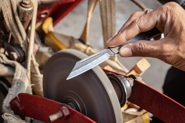 man doing knife sharpen at iron sharpener from different angle