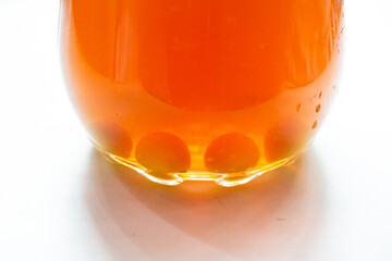 A decanter of orange fruit juice stands on the windowsill, and round sugar candies lie at the bottom