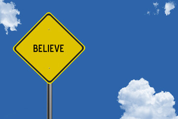 The word Believe on a yellow road sign on a blue sky background.  Inspirational concept for success in life.