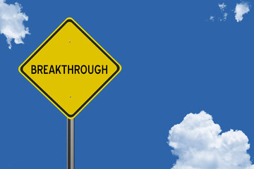 The word Breakthrough on a yellow road sign on a blue sky background.  Inspirational concept for success in life.