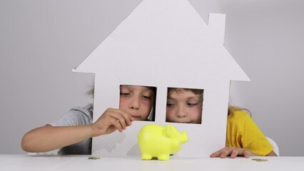 Boy and girl are looking out from the carton handmade house