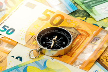 Black compass on euro banknotes