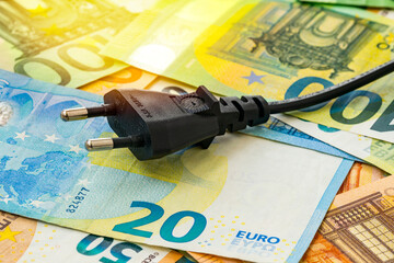 Black electric plug on euro banknotes