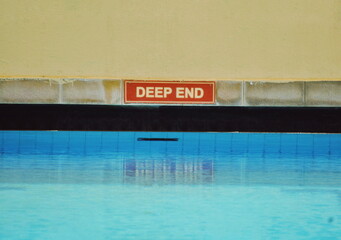 Deep End. swimming pool sign in the pool