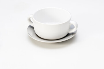 Simple white ceramic soup bowl with saucer, isolated on white