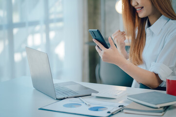 Portrait of smiling pretty young business woman sitting on workplace