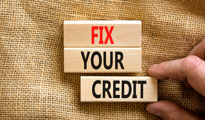 Fix your credit symbol. Concept words Fix your credit on wooden blocks on a beautiful canvas table canvas background. Businessman hand. Business, finacial and fix your credit concept. Copy space.