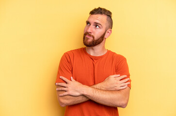 Young caucasian man isolated on yellow background dreaming of achieving goals and purposes