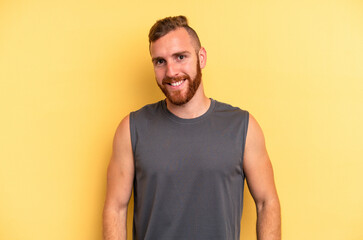 Fototapeta premium Young caucasian man isolated on yellow background confident keeping hands on hips.