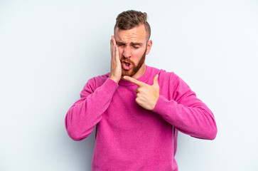 Young caucasian man isolated on blue background having a strong teeth pain, molar ache.