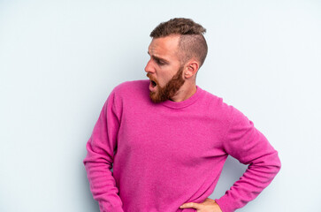 Fototapeta premium Young caucasian man isolated on blue background suffering a back pain.