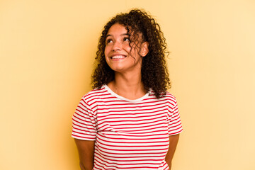 Young Brazilian woman isolated on yellow background relaxed and happy laughing, neck stretched showing teeth.