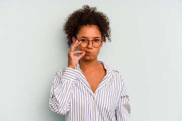 Fototapeta na wymiar Young Brazilian woman isolated on blue background with fingers on lips keeping a secret.