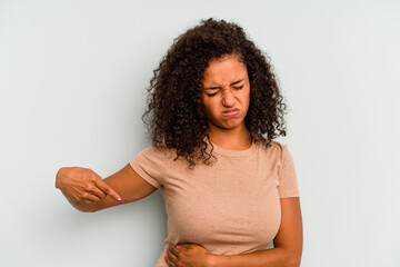 Young Brazilian woman isolated on blue background having a liver pain, stomach ache.