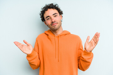 Fototapeta premium Young caucasian man isolated on blue background holding something little with forefingers, smiling and confident.