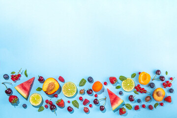 Fototapeta na wymiar Summer vitamin food concept, various fruit and berries watermelon peach mint plum apricots blueberry strawberry currant, creative flat lay on light blue background top view copy space