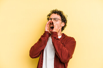 Young caucasian man isolated on yellow background shouting excited to front.