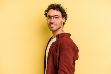 Fototapeta premium Young caucasian man isolated on yellow background confident keeping hands on hips.